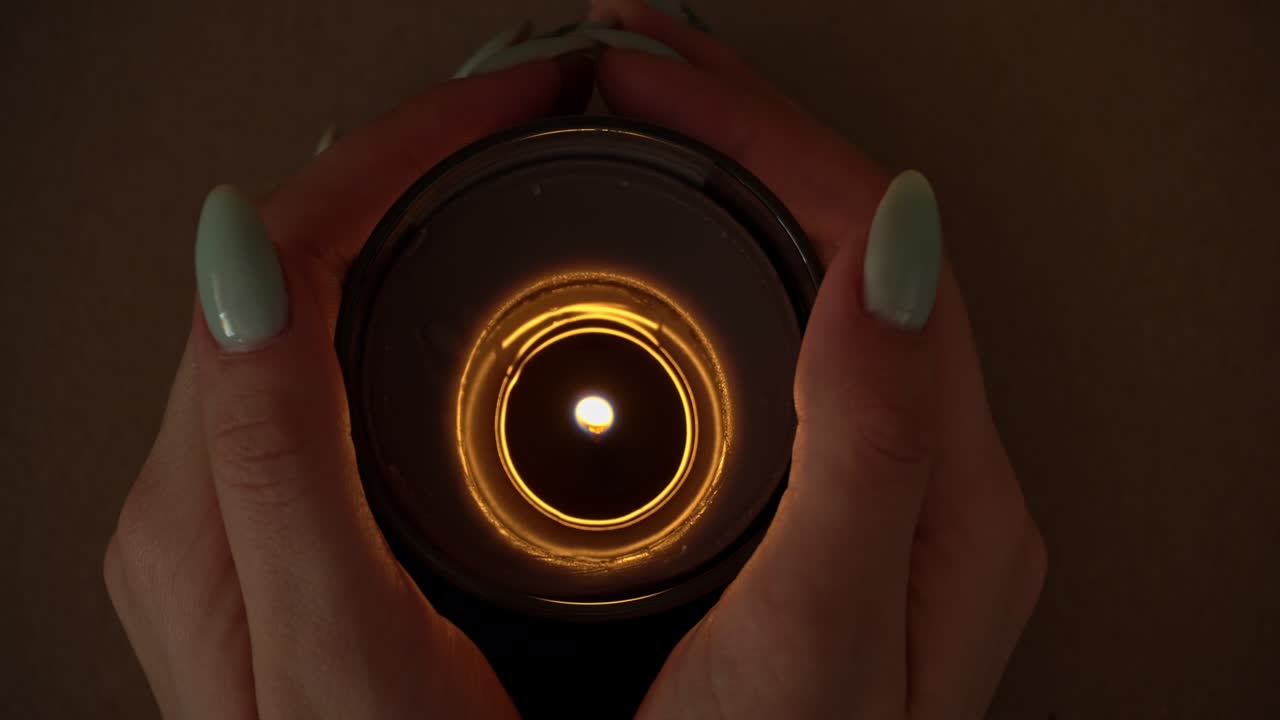 불은 아름다운 매니큐어를 가진 소녀의 손에 대기적으로 불타고 있습니다.