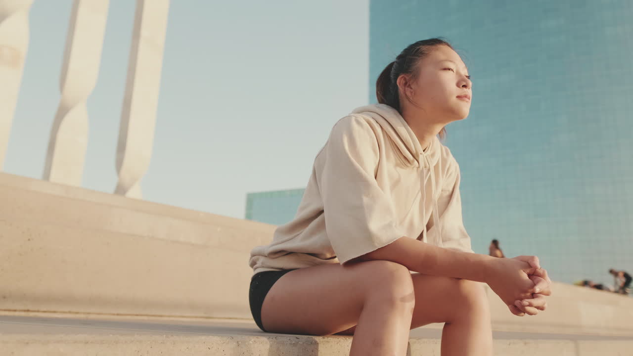 Asian woman sitting on steps in the city