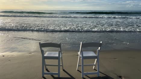 a serene beach with two folding chairs by gentle ocean waves a serene beach scene with two white folding chairs by gentle ocean waves creating a tranquil atmosphere for relaxation and connection with nature