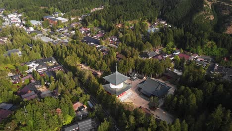 Aerial-Drone-Panoramic-Japanese-Village-Koyasan-Temple-Mount-Koya-buddhist-Japan-travel-destination,-forest-around-religious-architecture