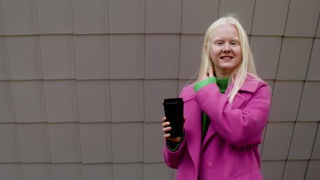 happy woman holding coffee cup outdoors