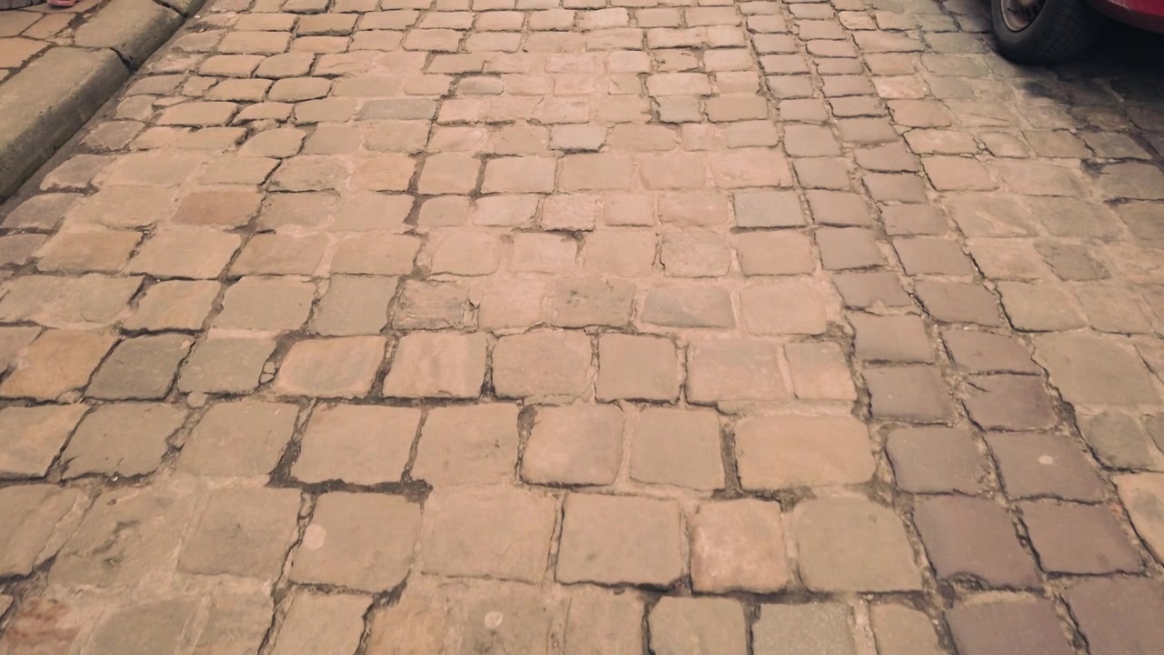 Old street of paving stone and parked cars.