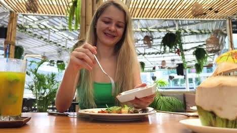 woman enjoying a meal at a tropical restaurant