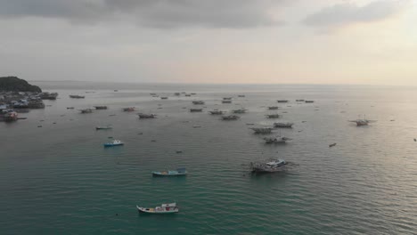 Amplia-Vista-De-Los-Barcos-Atracados-Cerca-De-La-Aldea-De-Tanjung-Binga-Durante-La-Puesta-De-Sol,-Aérea