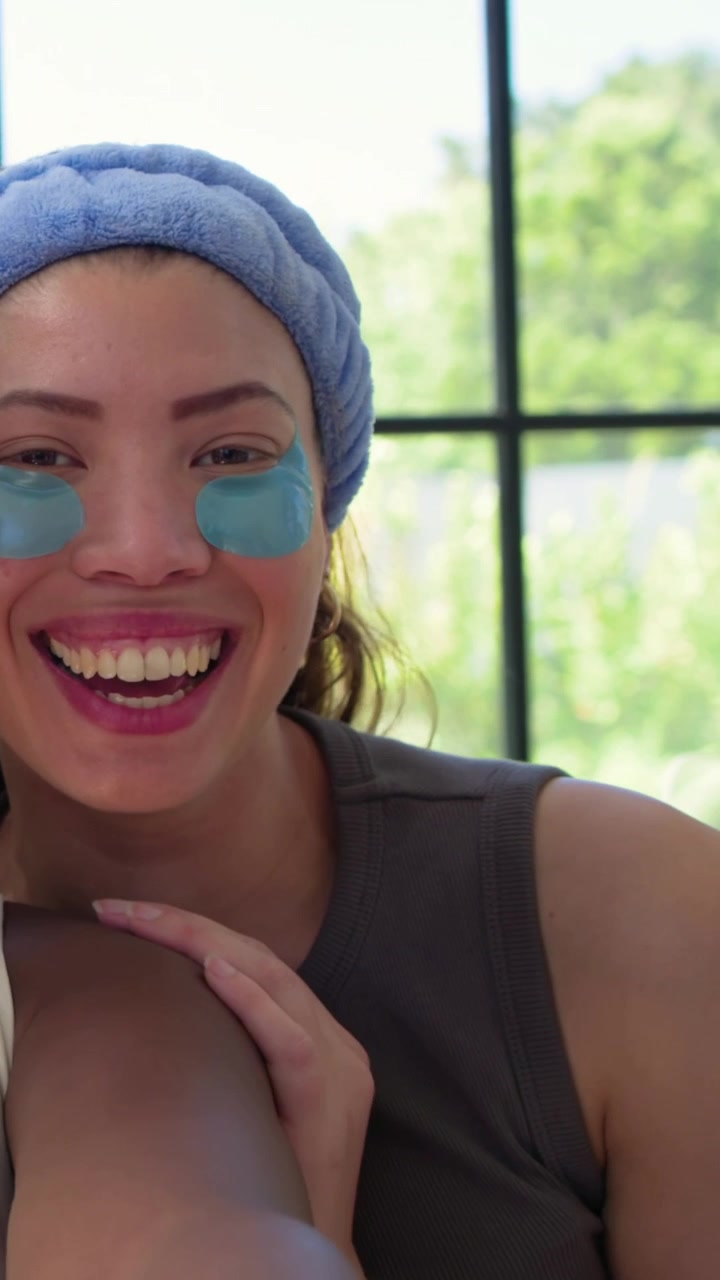 Vertical video: Friend talking, woman turning, smiling, touching arm on couch, with headband, gels