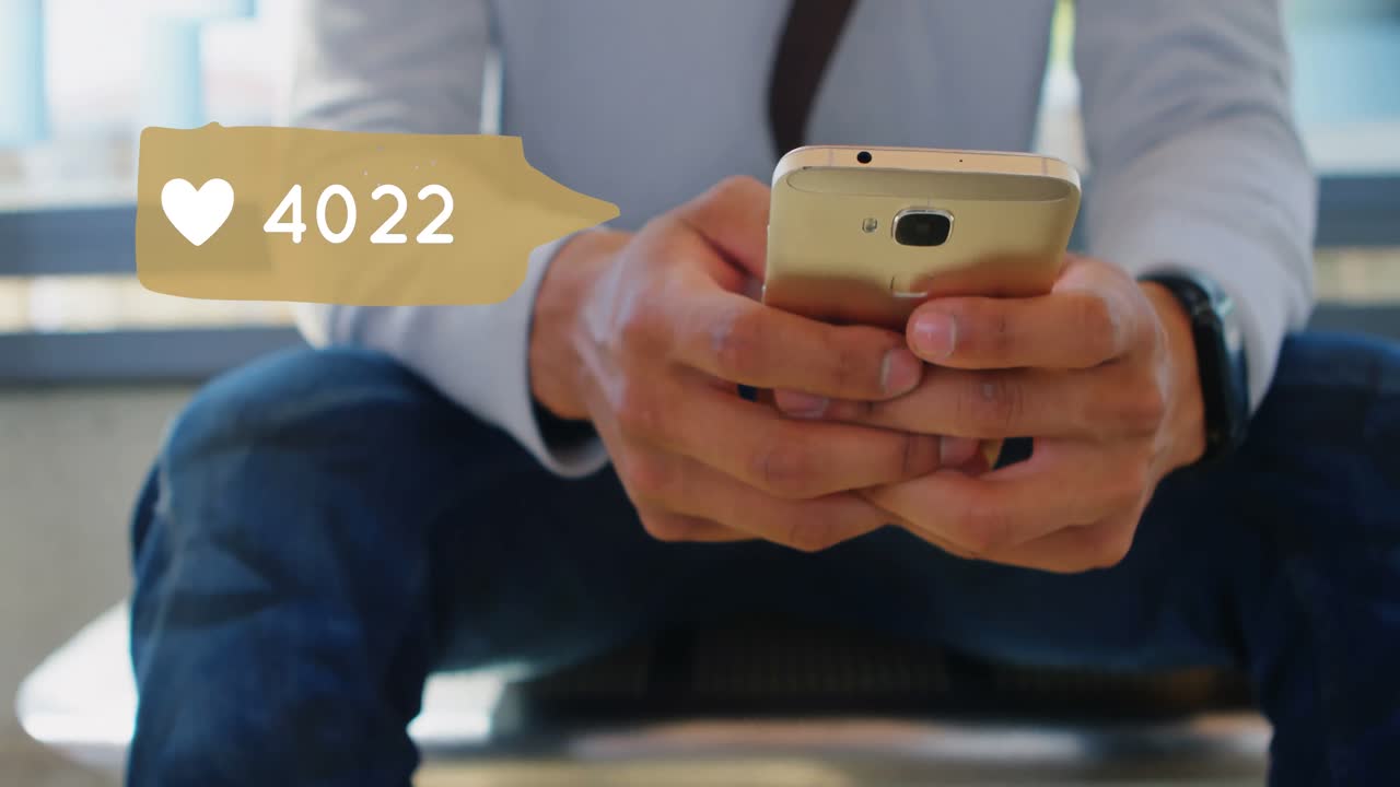 hombre sentado en la oficina mientras navega en su teléfono 4k