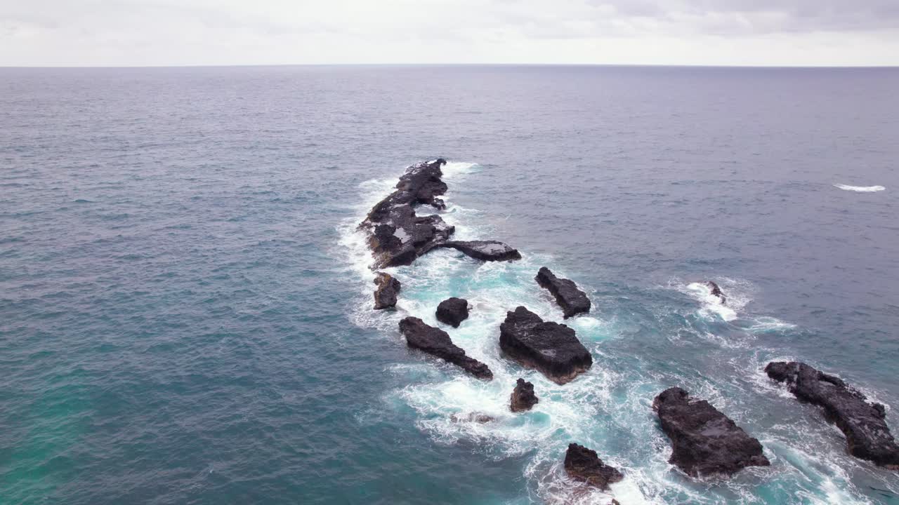Stormy waves crash on Praia Piscina, São Tomé, a dramatic blend of wild ocean power and serene tropical beach landscape
