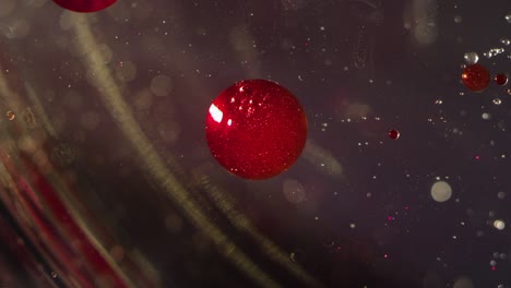 abstract red liquid sparkling orbs floating in clear liquid bokeh background texture