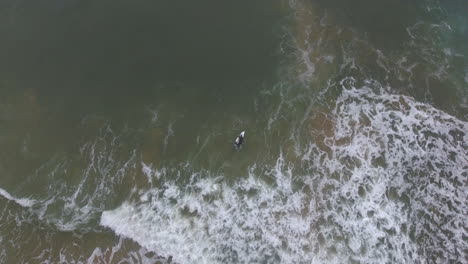 Cinematic-flying-of-surfers-surfing-along-coast-of-East-London-South-Africa-aerial