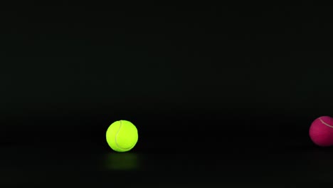 various colored tennis balls moving in darkness