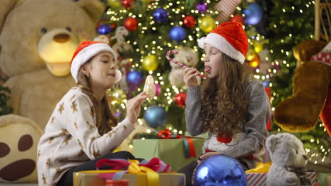 girls celebrating christmas with candy canes and presents