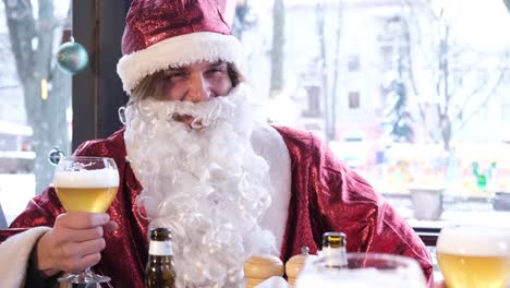 friends in santa claus costumes are having fun at a new years party drinking beer in a pub friends in santa claus costumes are having fun at a new years party drinking beer in a pub close up