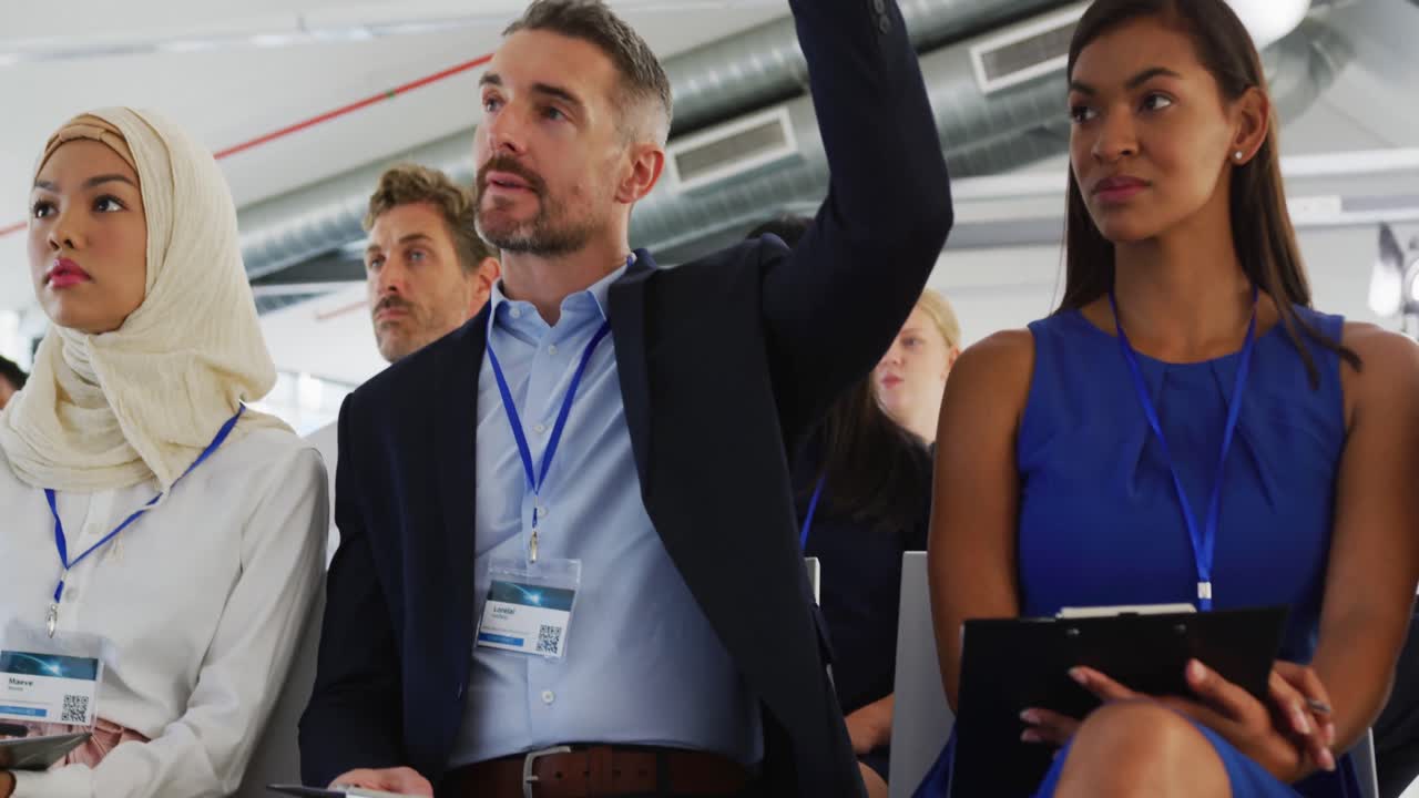 hombre de negocios levantando la mano en una conferencia