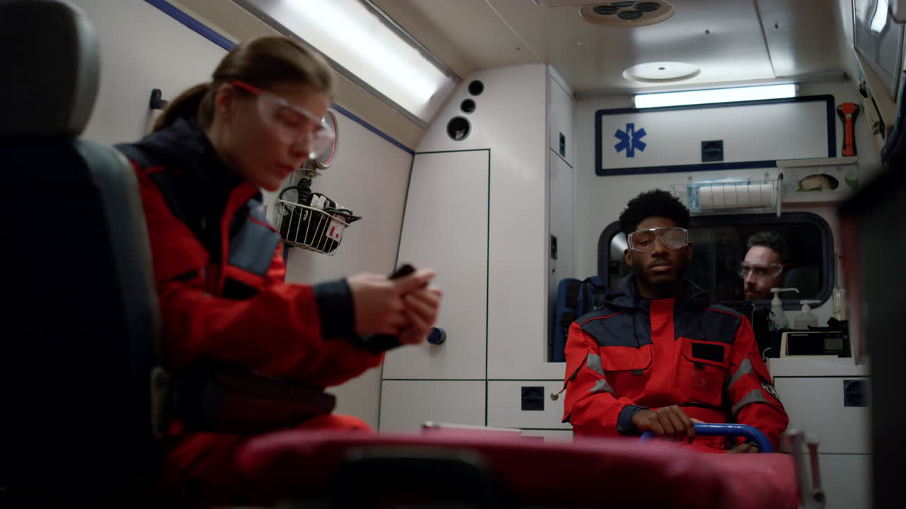 응급 의료 보조원 들 이 구급차 에서 911 호출 을 운전 하고 있다