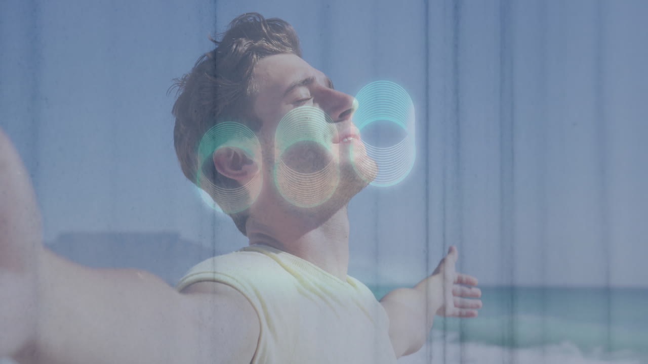 On beach, man with abstract circular animation overlay, relaxing by ocean waves