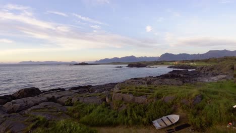fotografía aérea de una pequeña cabaña y barcos en una orilla de lofoten, noruega