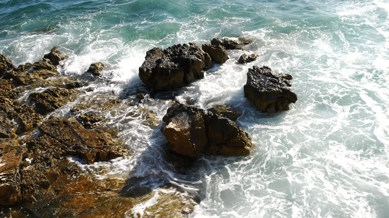 Primo piano della pietra sulla spiaggia albanese frantumata dalle onde del Mar Ionio.