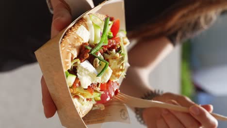 healthy baguette burger in hands of woman, close up dolly out, vertical shot