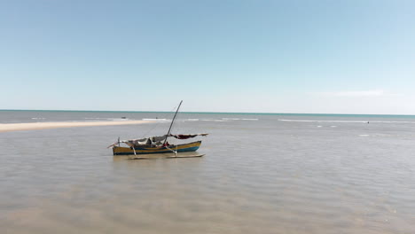 a small wooden boat is beached and abandoned along the shallow waters of the coast of africa