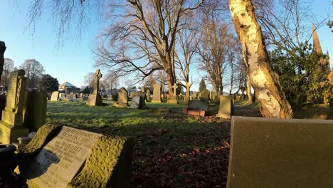 fpv flying around golden hour headstones in snowy autumn sunrise churchyard cemetery