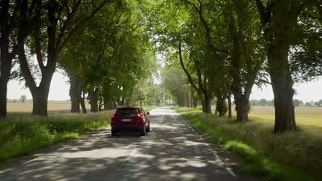 red volvo car state sedan suv driver driving passing by lonely road street countryside sunday drive weekend roadtrip vacation going speeding fast quick safety blinking overtaking pass calmly field