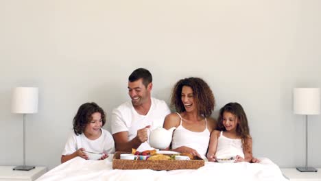 Cute-family-having-breakfast-in-bed