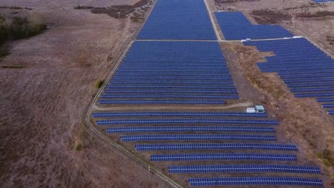 The-future-of-green-energy:-aerial-view-over-solar-panel-farm-system-in-rural-area