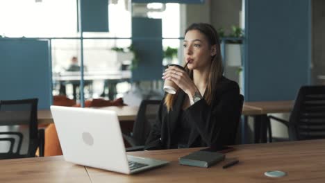 Una-Mujer-Bonita-Sentada-En-La-Oficina-Bebe-Café-Y-Reflexiona