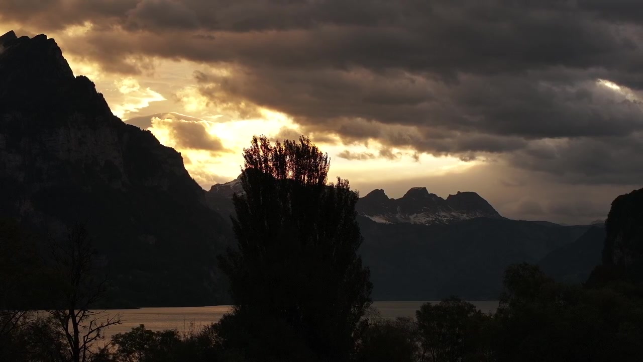 Moody sunset over Walensee, Switzerland, with dramatic clouds and silhouetted mountains