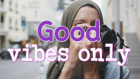 animation of text good vibes only over woman taking photo