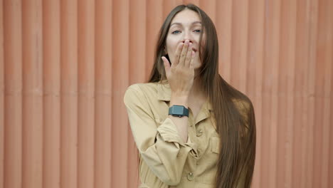 woman in beige jumpsuit expressing joy