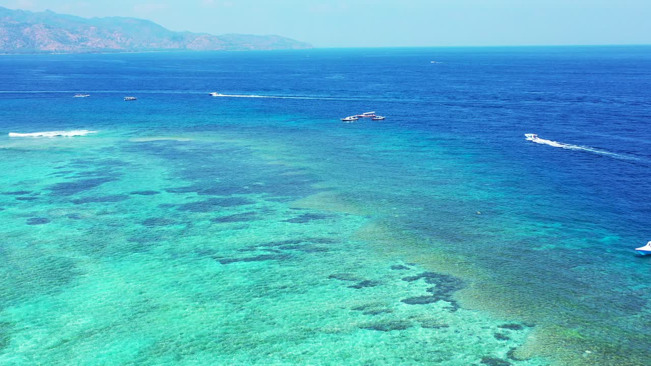 speed boats on top of colorful shallow coral reef and algae plantations on the coast of Nusa Penida, Bali