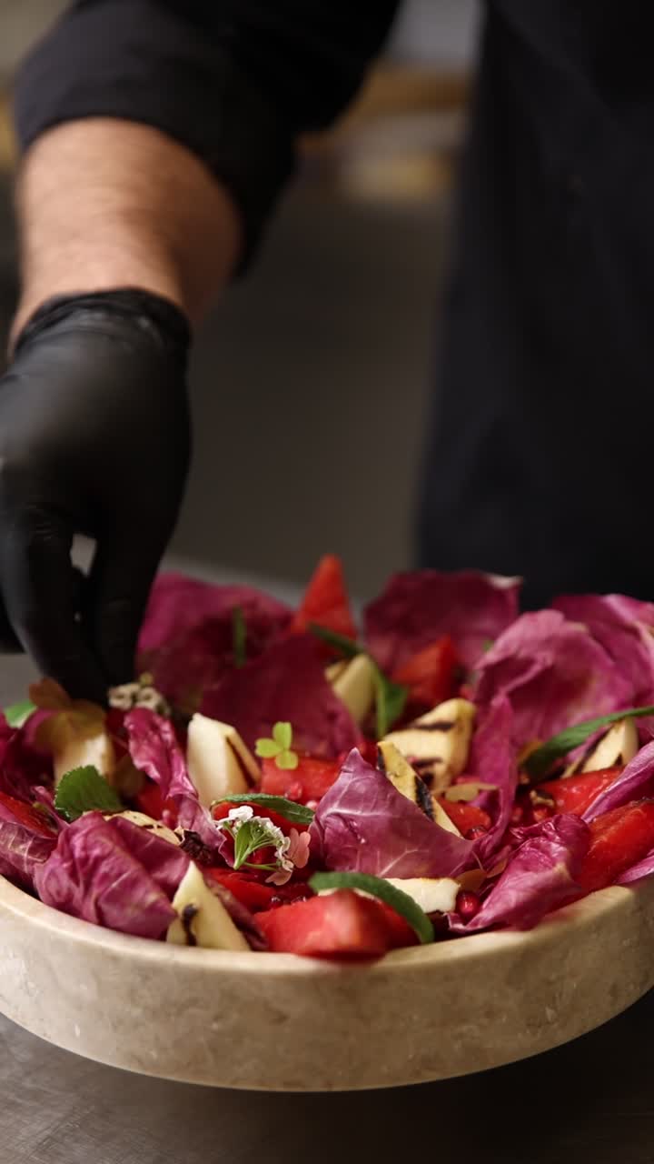 Chef che guarnisce un'insalata fresca e colorata con fiori commestibili