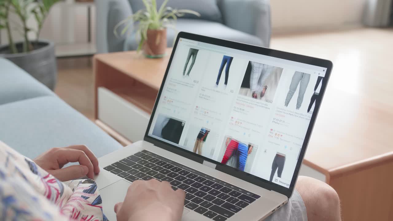 Person browsing men's clothing online on laptop