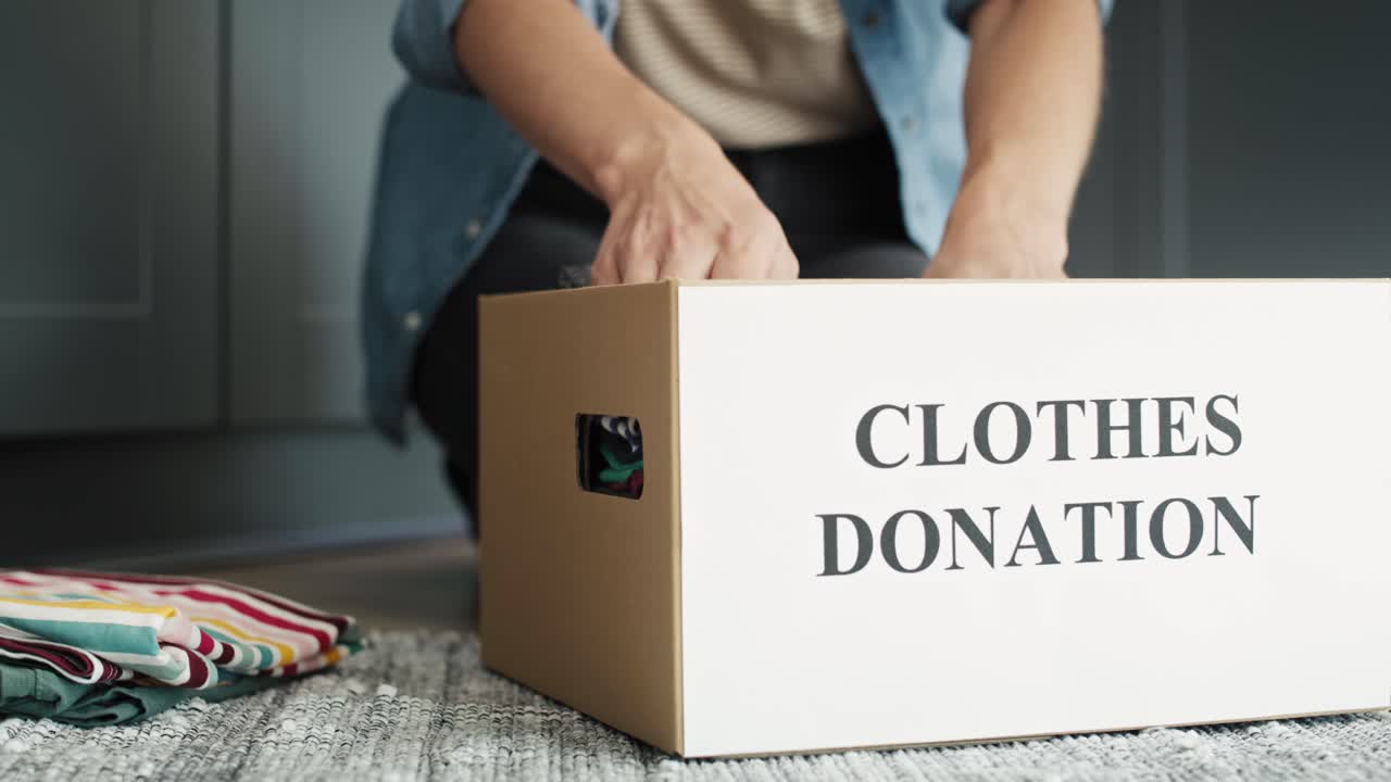 Video of woman preparing clothes for donation