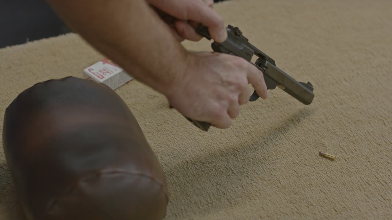 슬라이드를 뒤로 끌고 카트리지를 밖으로 내보내는 방법으로 권총을 손으로 풀어내는 것