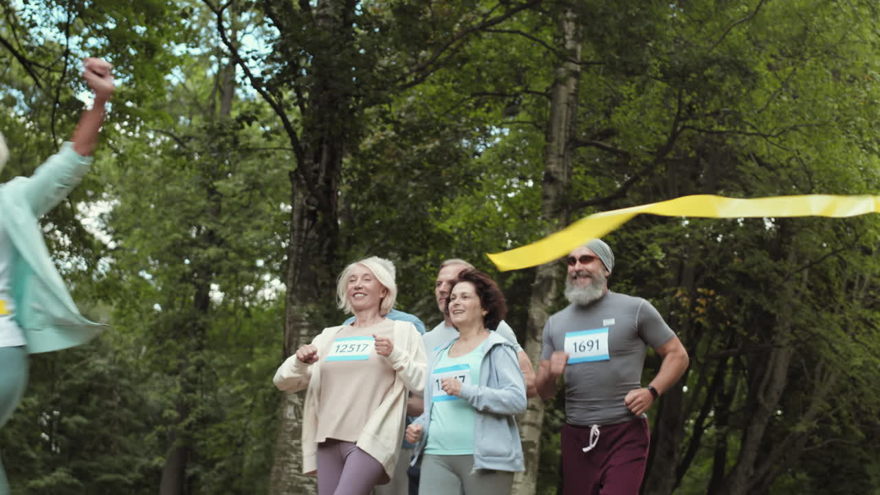 Group of seniors crossing the finish line in a park race