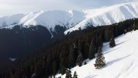 Snow-covered-Batrana-Peak-in-Iezer-Papusa-Mountains,-Arges,-Romania,-aerial-view