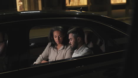 pareja de negocios en el coche por la noche