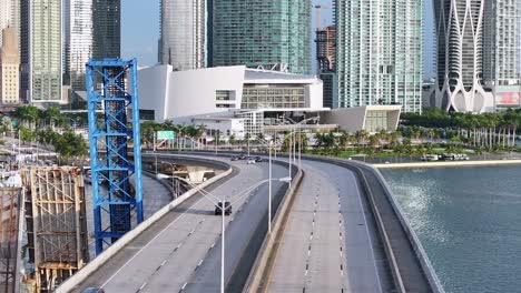 Toma-Aérea-Inclinada-Hacia-Arriba-Del-Tráfico-En-La-Carretera-En-El-Bayfront-Park-De-Miami-Durante-El-Día-Soleado