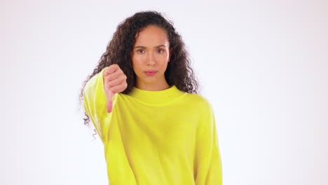 face, hand and thumbs down by woman in studio