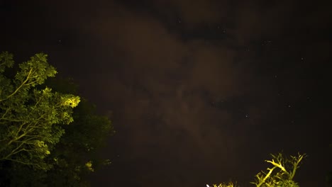 Hyper-lapse-panning-across-the-dark-night-sky-as-passing-clouds-obscure-the-view-of-the-glistening-stars-of-the-milky-way-orbiting-above,-South-Africa