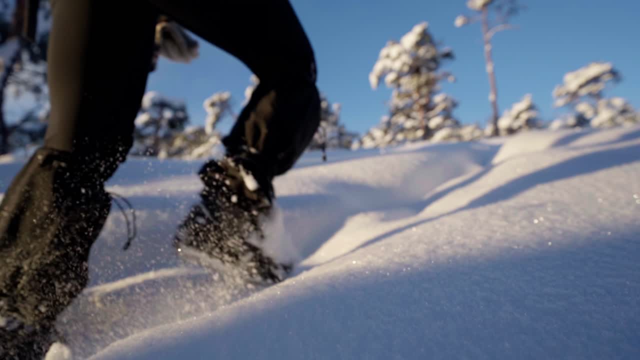 mujer caminando a través de la nieve en un impresionante paisaje de invierno, ángulo bajo en cámara lenta