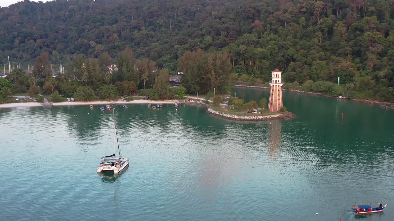hermoso paisaje de perdana quay light house adecuado en un promontorio, drone alrededor de la costa con yates y barcos de pesca navegando en el mar en la isla langkawi, kedah, archipiélago de malasia