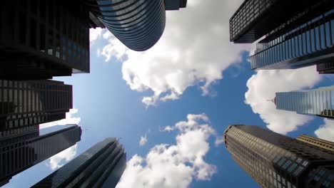 expansive skyview through tall skyscrapers: a majestic perspective of urban architecture and cloud patterns captured from below