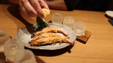 person enjoying grilled fish at a japanese restaurant