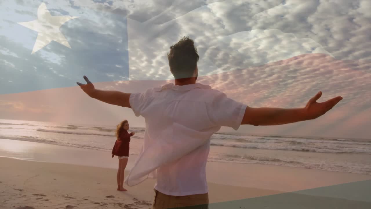 Casal de frente para a praia, com a brisa crescente ondulando as roupas, com sobreposição de bandeira em movimento para um retiro de saúde.