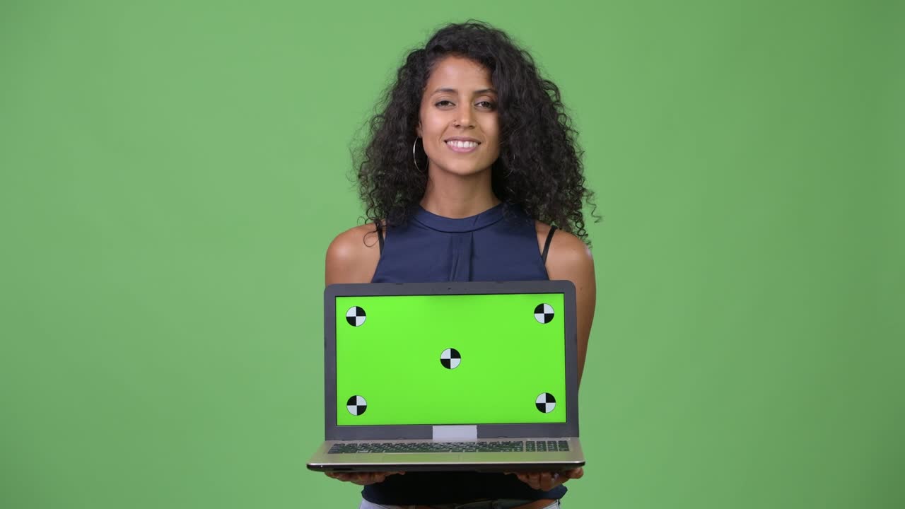 Young beautiful Hispanic businesswoman showing laptop