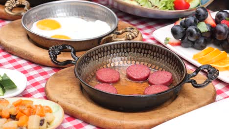 delicious turkish breakfast with eggs, sausage, fruit and salad