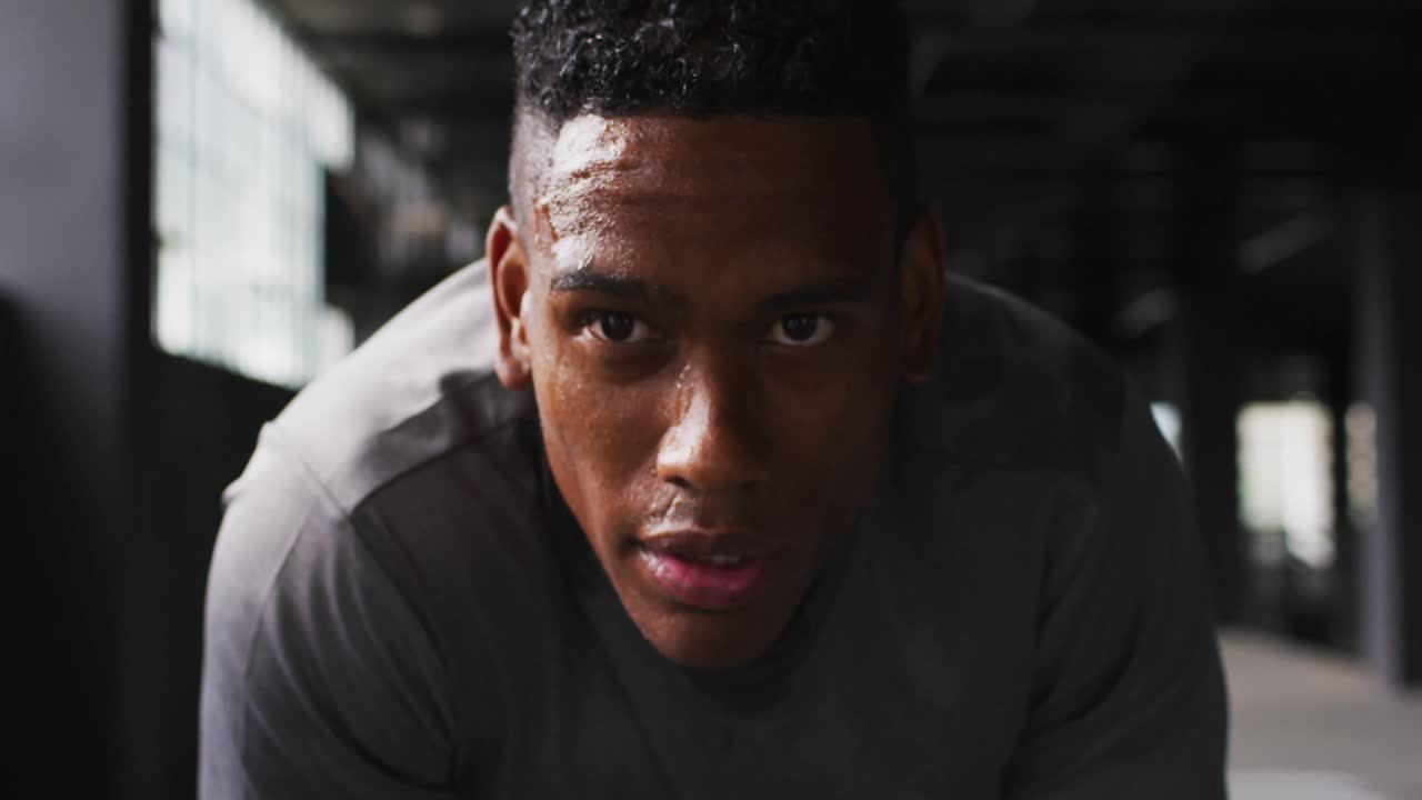 retrato de un hombre afroamericano tomando un descanso respirando pesadamente y mirando a la cámara